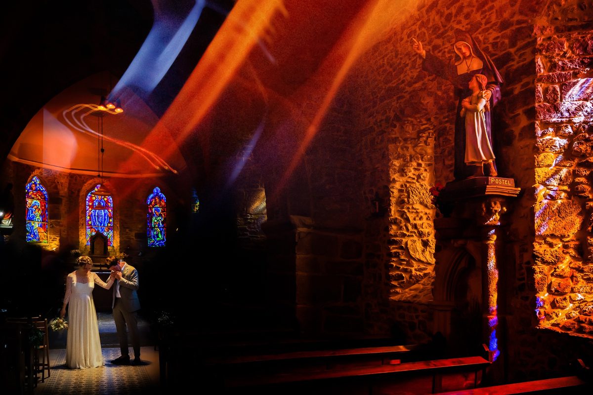 Photographe mariage Normandie — couple église vitraux lumière rouge — Arnaud Chapelle